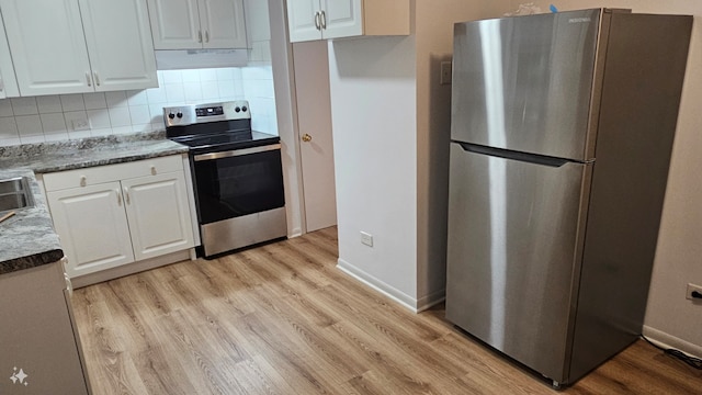 kitchen with white cabinetry, tasteful backsplash, extractor fan, appliances with stainless steel finishes, and light wood-type flooring