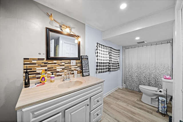 bathroom with backsplash, hardwood / wood-style floors, walk in shower, toilet, and vanity