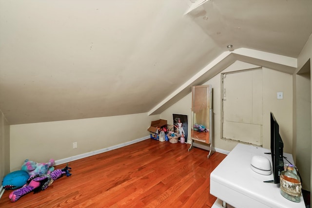 additional living space featuring vaulted ceiling and hardwood / wood-style floors