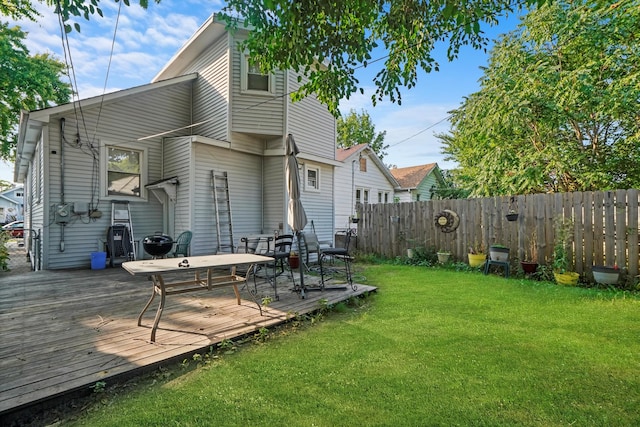 rear view of house featuring a yard and a wooden deck