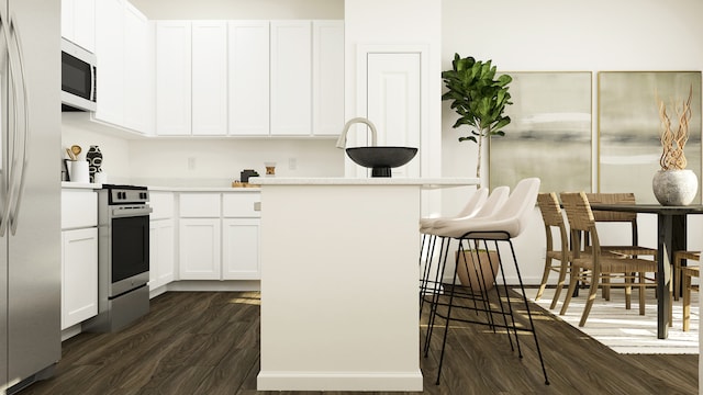 kitchen with white cabinets, a breakfast bar area, and dark hardwood / wood-style flooring