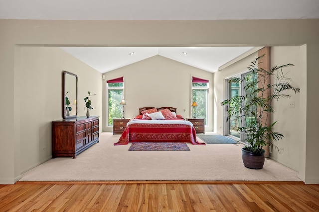 bedroom featuring vaulted ceiling, hardwood / wood-style flooring, and access to exterior