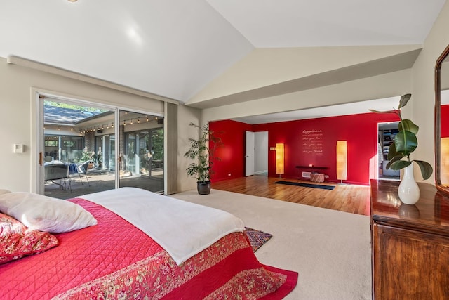 bedroom with wood-type flooring, lofted ceiling, and access to exterior