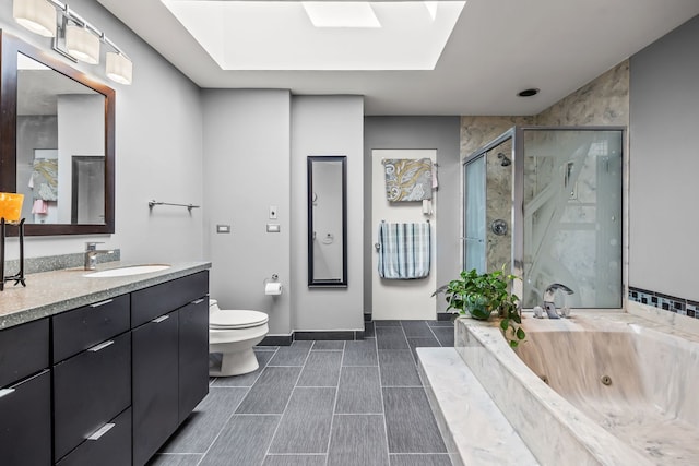 full bathroom with a skylight, separate shower and tub, vanity, and toilet