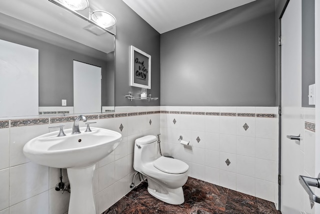 bathroom with tile walls, toilet, and decorative backsplash