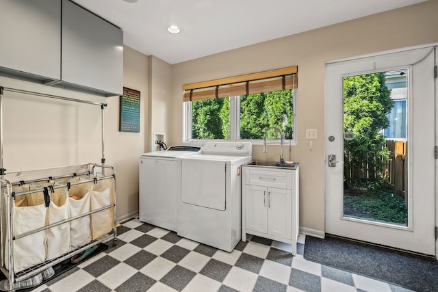 washroom featuring cabinets, sink, washer and dryer, and a wealth of natural light