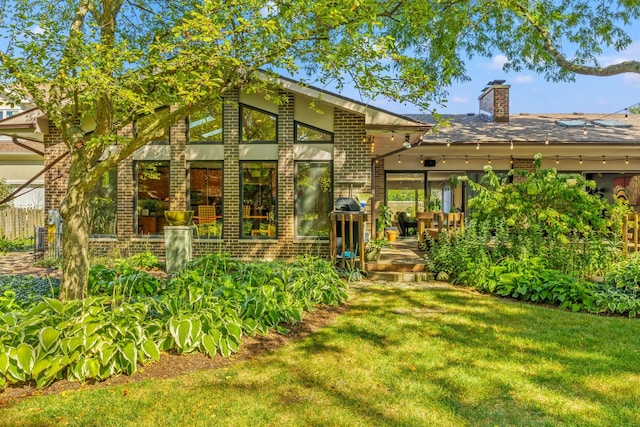 back of property with a yard and central AC unit