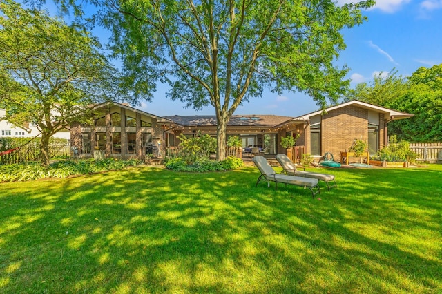 rear view of property with a lawn and a patio area