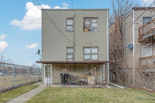 rear view of property featuring a yard and a patio