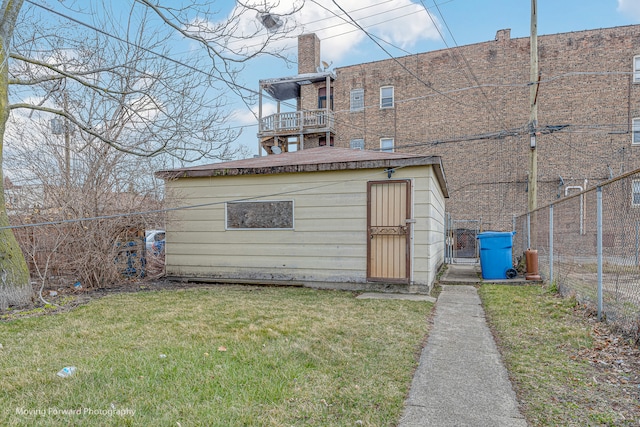 back of property featuring a lawn and a storage unit