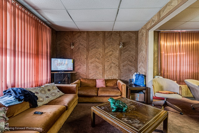 carpeted living room featuring a drop ceiling