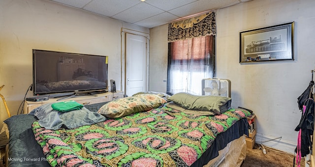 carpeted bedroom featuring a paneled ceiling