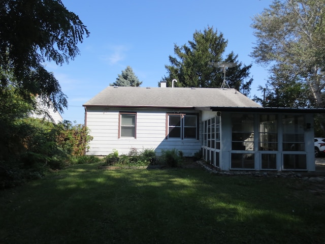 rear view of house featuring a yard