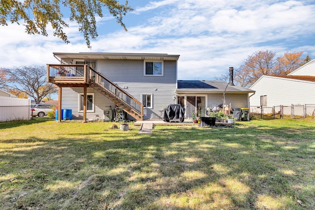 rear view of property with a yard and a deck