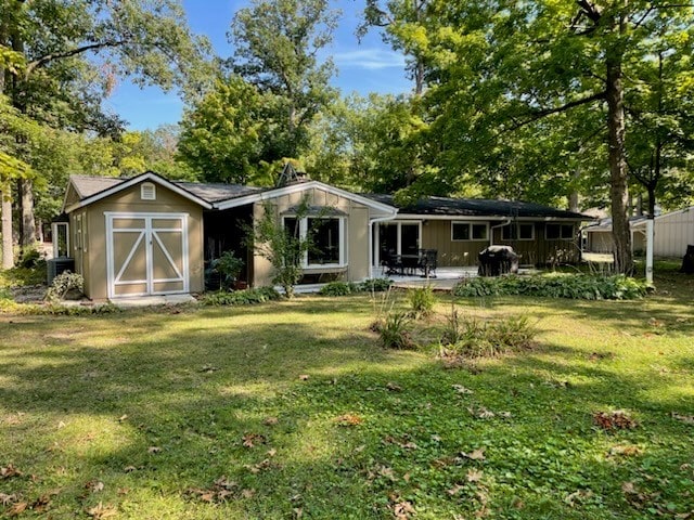 back of property featuring a storage shed, a patio area, and a yard