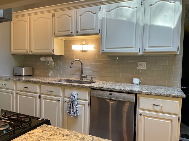 kitchen with stainless steel dishwasher, sink, white cabinets, and tasteful backsplash