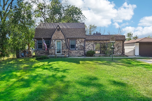 view of front of house with a garage, a front yard, and an outdoor structure