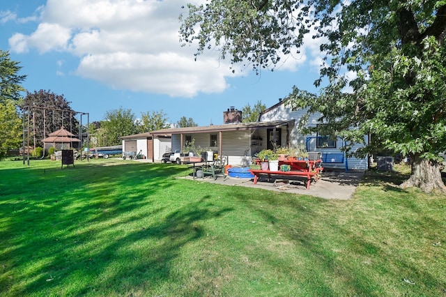 back of property with a yard, a deck, and a patio area