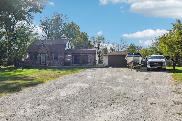 view of front of home featuring an outdoor structure, a garage, and a front lawn