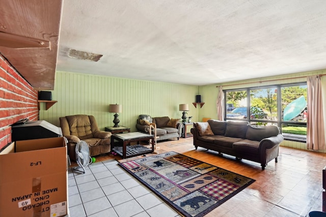 living room featuring a brick fireplace and a textured ceiling