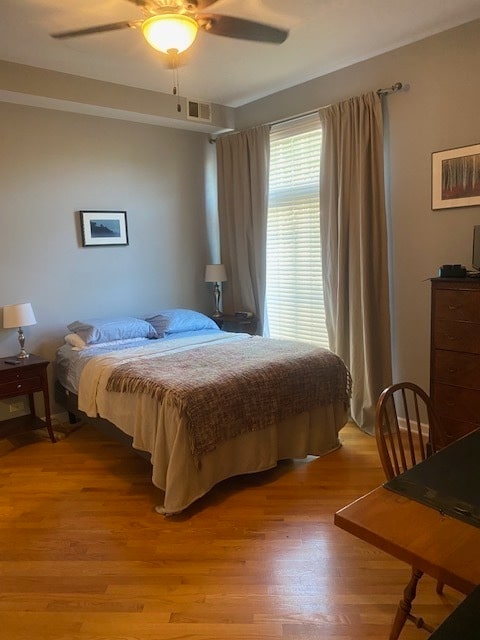 bedroom with ceiling fan and light hardwood / wood-style floors