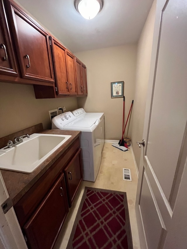 washroom featuring separate washer and dryer, cabinets, and sink