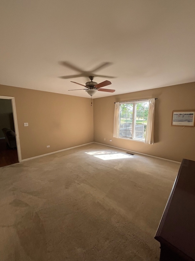 carpeted spare room with ceiling fan