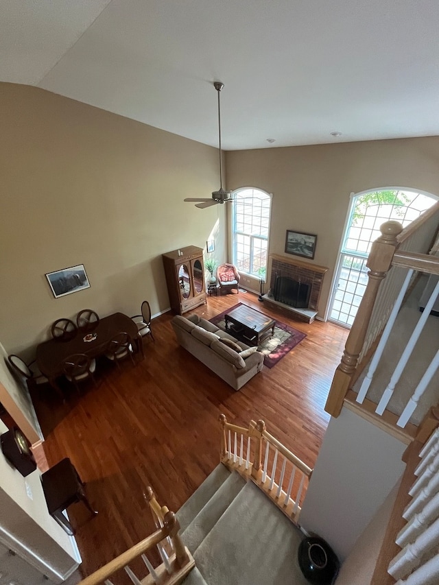 living room with lofted ceiling, ceiling fan, and hardwood / wood-style flooring