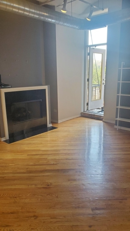 unfurnished living room featuring ceiling fan and hardwood / wood-style flooring