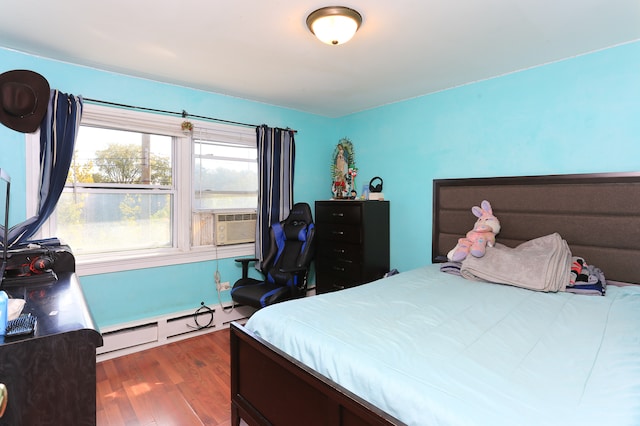 bedroom featuring a baseboard heating unit, dark wood-type flooring, and cooling unit