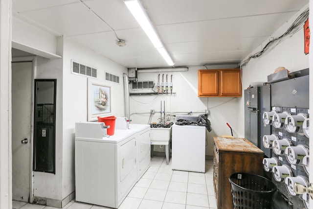 washroom featuring light tile patterned floors, cabinets, and washing machine and dryer