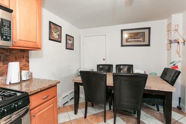 dining space with a baseboard radiator and light tile patterned floors