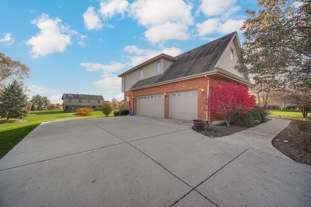 view of side of property with a yard and a garage