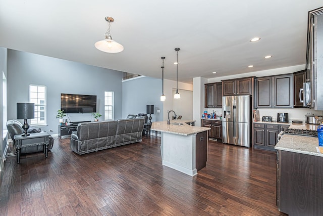 12740 Timber Wood Cir, Plainfield, IL 60585 - kitchen featuring stainless steel appliances, open floor plan, dark brown cabinetry, a sink, and pendant lighting
