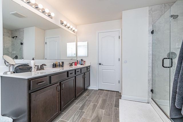 12740 Timber Wood Cir, Plainfield, IL 60585 - full bath featuring a stall shower, wood tiled floors, double vanity, and baseboards