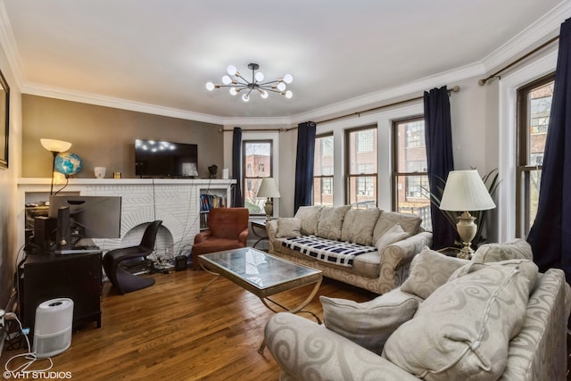 living room featuring a fireplace, crown molding, wood-type flooring, and a chandelier