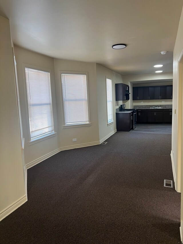 interior space with plenty of natural light and dark carpet