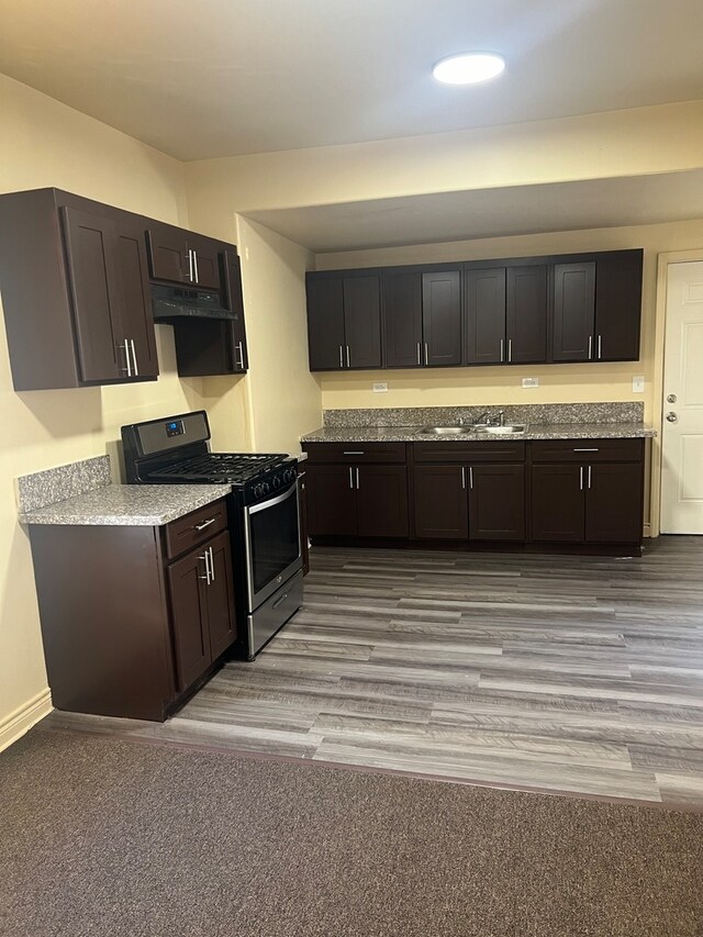 kitchen featuring light hardwood / wood-style floors, sink, dark brown cabinets, and stainless steel range with gas stovetop