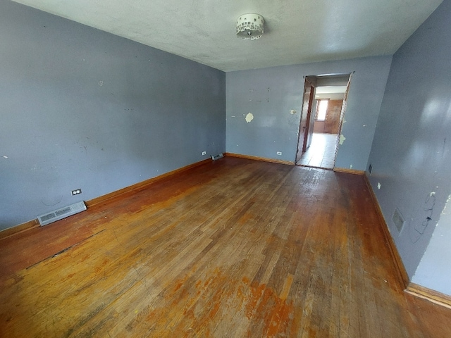 empty room featuring a textured ceiling and wood-type flooring