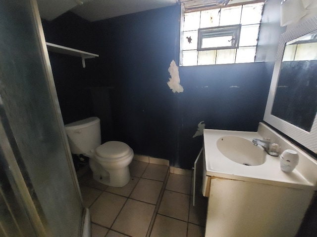 bathroom with vanity, toilet, a wealth of natural light, and tile patterned floors