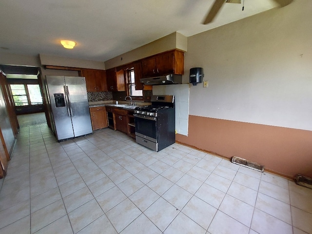 kitchen with appliances with stainless steel finishes, light tile patterned floors, sink, and ceiling fan