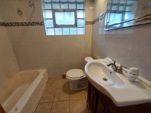 full bathroom featuring tile patterned flooring, toilet, tile walls, tiled shower / bath combo, and vanity