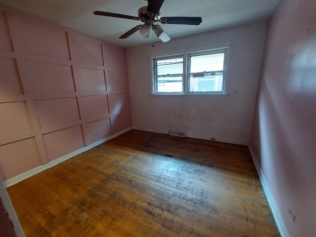 unfurnished room with visible vents, ceiling fan, and wood finished floors