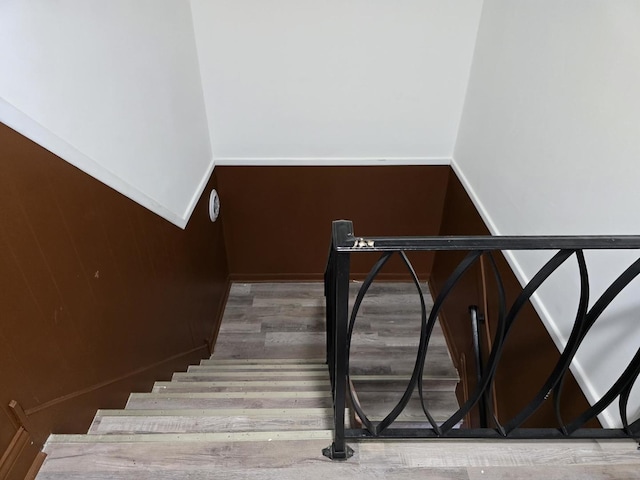 stairway featuring wood finished floors and baseboards