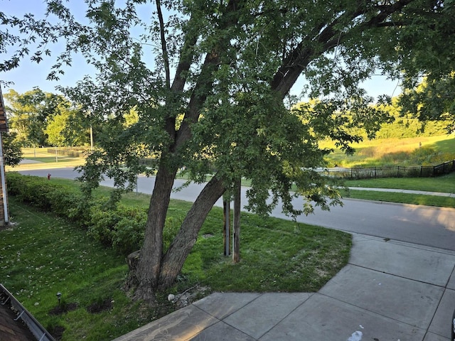 view of home's community featuring a lawn and fence