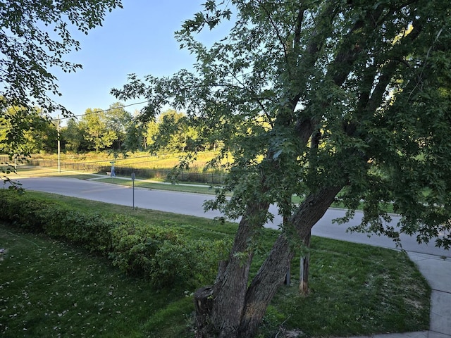 view of tennis court featuring a yard