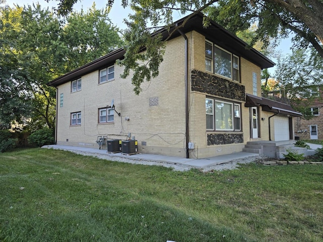 view of property exterior featuring central AC unit, a lawn, brick siding, and crawl space