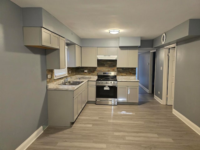 kitchen featuring gray cabinets, gas range, sink, and light hardwood / wood-style floors