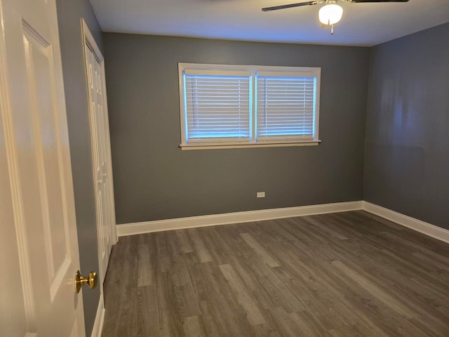 spare room with dark wood-type flooring and ceiling fan