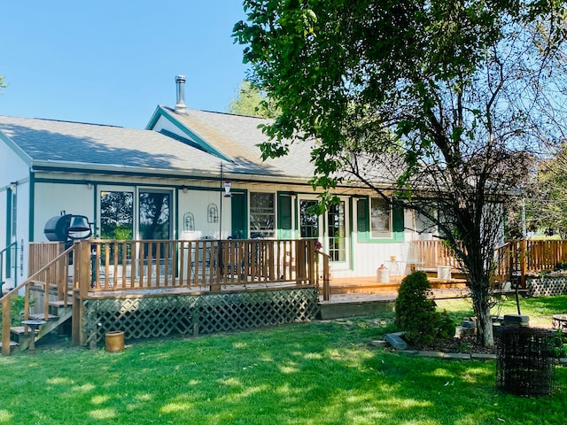 rear view of house featuring a lawn and a wooden deck